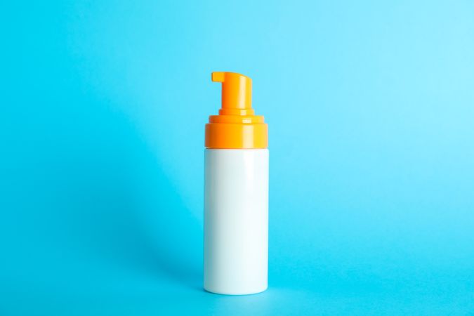 Sunscreen spray on color background, space for text