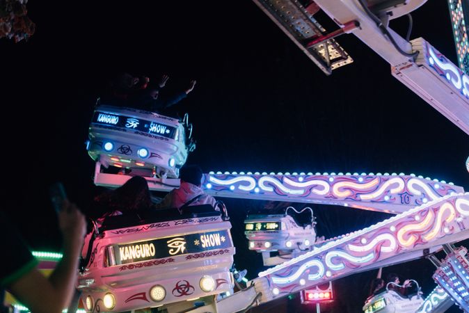 People on illuminated amusement ride in park