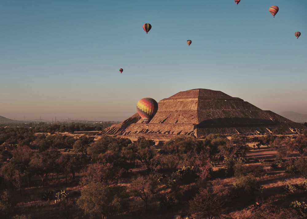 A few hot air balloons in flight over pyramids in Teotihuacan Valley