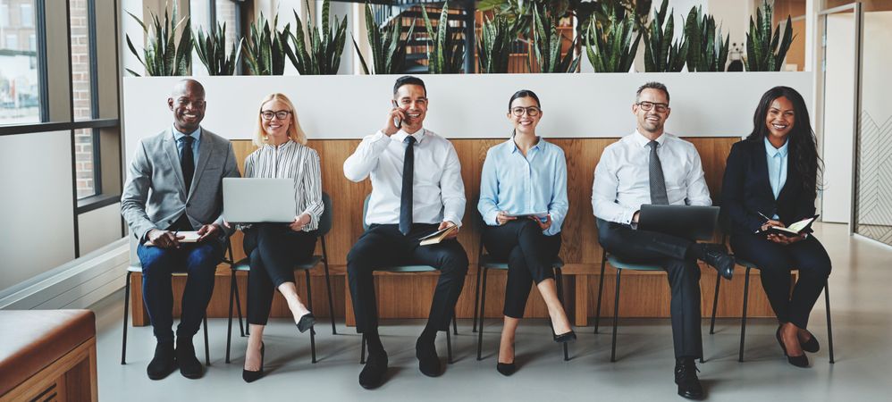 Group of people sitting on bench in office
