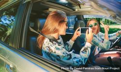 Woman taking photo to her friend inside of car 4OddXj
