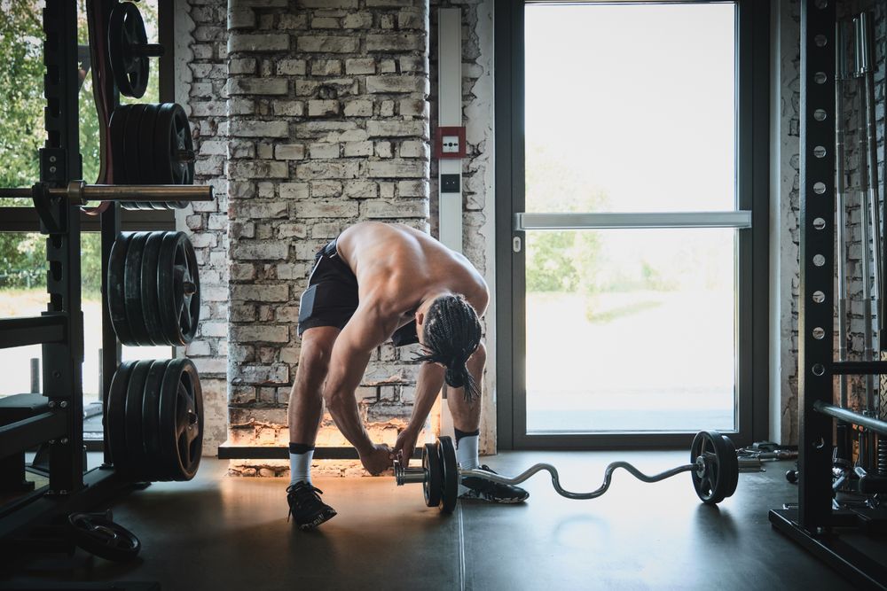 Black man exercising with barbell in gym