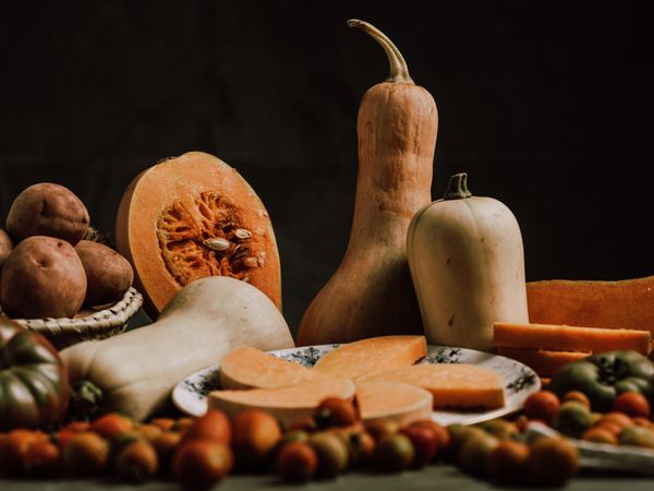Still life of sliced pumpkin on plate and ripe tomatoes