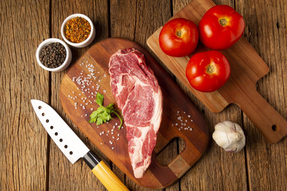 Raw ancho meat ready to roast on a wooden cutting board.