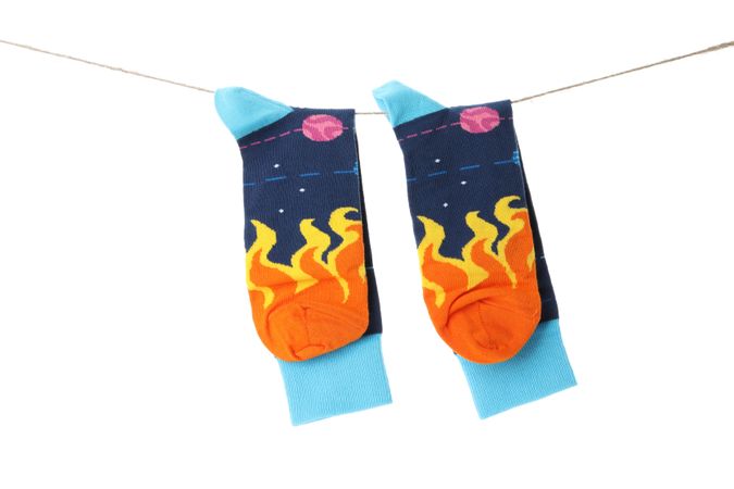 Socks hanging on twine, isolated on light background