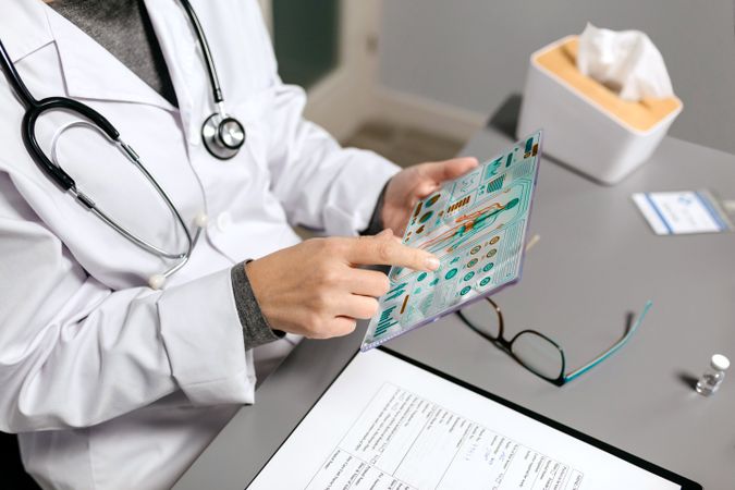 Female doctor touching transparent tablet with medical digital diagnostic on screen
