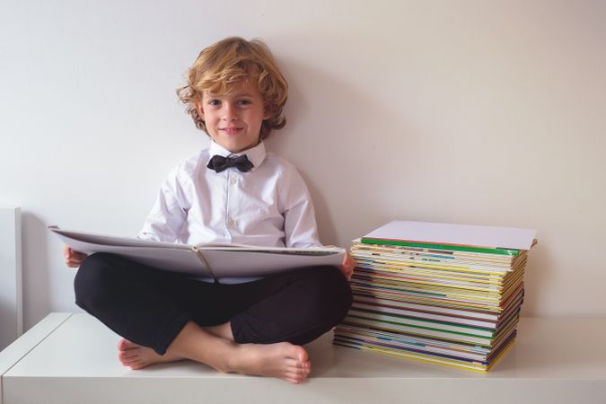 Schoolboy in suit reading book