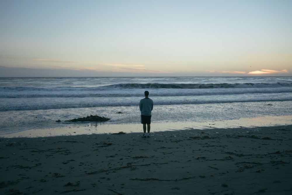 Back of man walking on beach in California