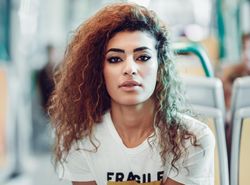 Portrait of Arab woman sitting in train carriage looking at camera