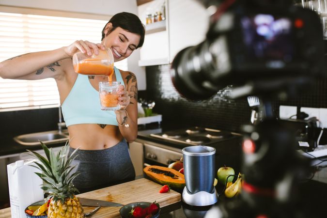 Food blogger recording a vlog on camera on fresh and healthy smoothie