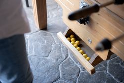 Close up of some yellow table football balls ready to be played in the dispenser