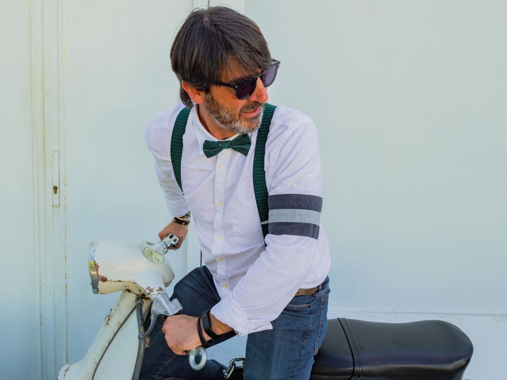 Trendy man sitting on vintage scooter