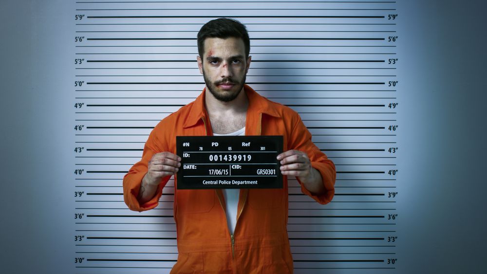 In a Police Station Arrested Man Getting Front-View Mug Shot.