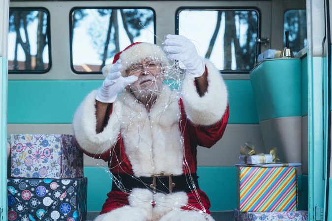 Santa Claus sitting with gifts and garland