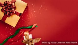 Flat lay of holiday wrapped presents against red background 5XwzK0