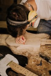Cropped image of young person making an electric guitar from wood 4OXDJb