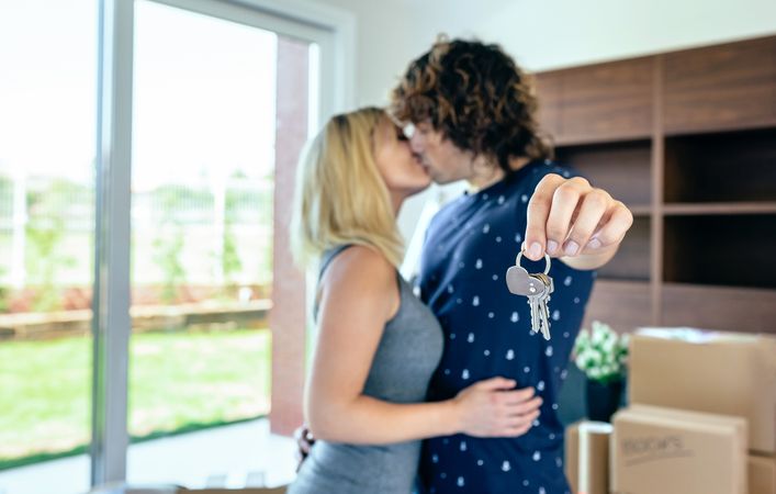 Moving couple kissing and showing keys