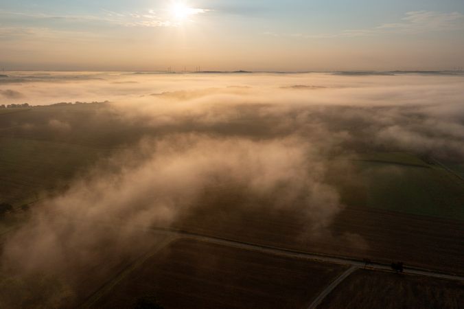 Drone view in the morning with foggy agricultural fields at golden hour