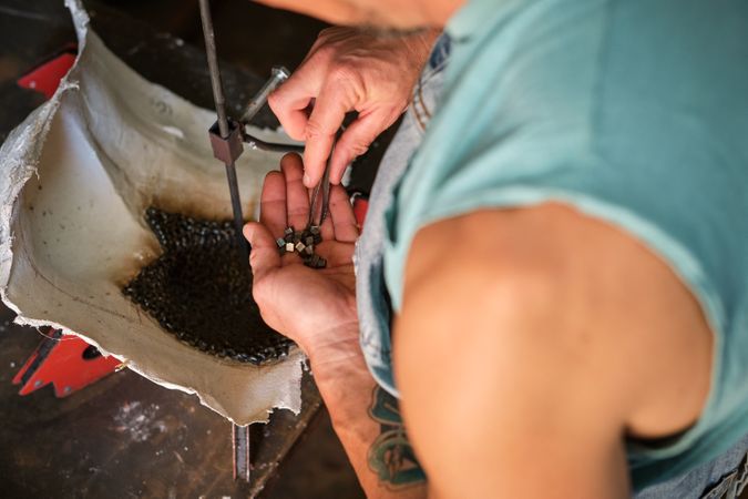 Faceless welder working on metal details in workshop