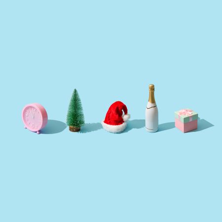 Row of various winter items; tree, champagne, present, Santa hat