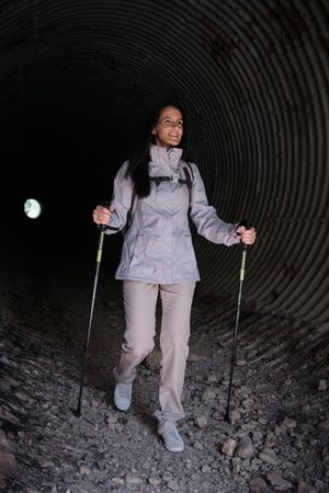Positive Hispanic woman walking in tunnel