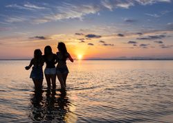 Women embracing on sunset at sea