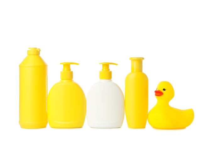Bathroom bottles and rubber duck isolated on light background