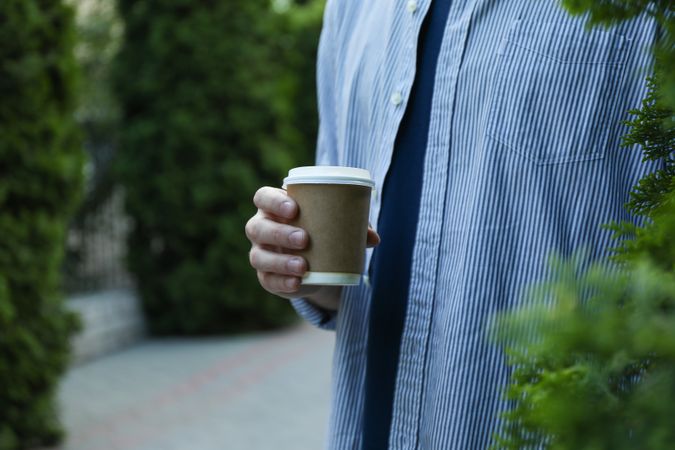 Young man holding a cup of coffee. Space for text