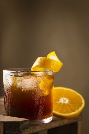 Negroni cocktail with orange, on wooden background.