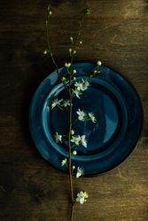 Top view of spring table setting with blooming tree branch on blue plate