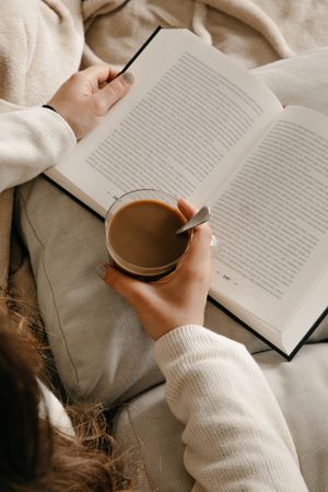 Person reading a book on the bed