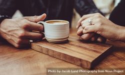 Man holding hand of his wife while having coffee at a cafe 4BQVd5