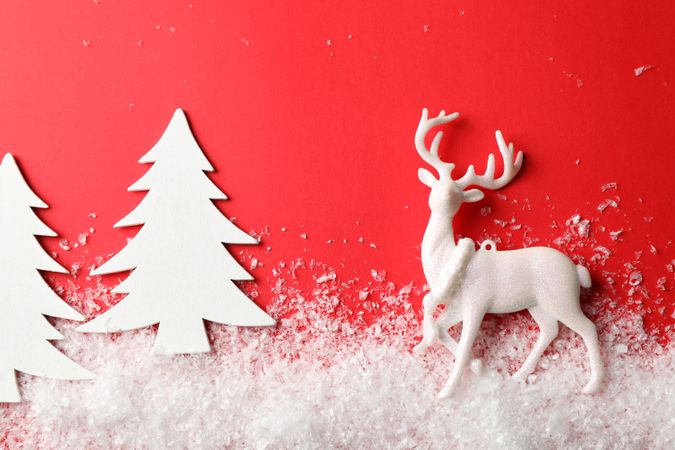 Snow, decorative trees and reindeer on red background, space for text