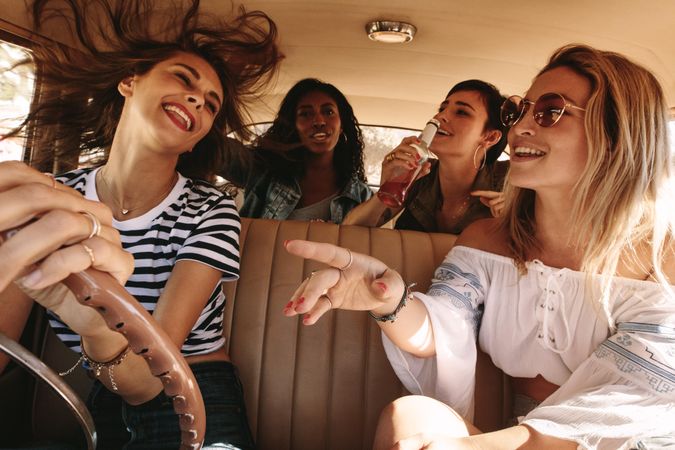 Women having fun on road trip laughing and enjoying the ride