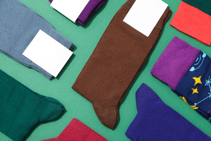 Socks with blank label on green background, space for text