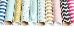 Rolls of festive wrapping paper on plain background. Space for text