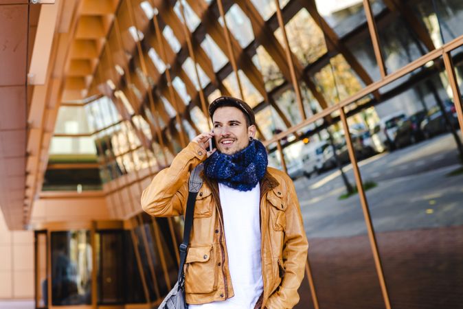 Stylish guy using smartphone outside modern building