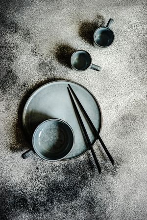 Top view of plate with chopsticks and mugs