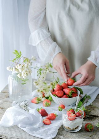 Confectioner cooking dessert of ripe strawberries