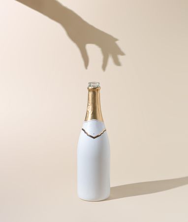 Champagne bottle with woman’s hand shadow