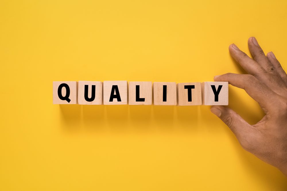quality word on wooden blocks isolated on yellow background