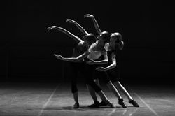 Grayscale photo of three women dancing on stage 4OXXRb