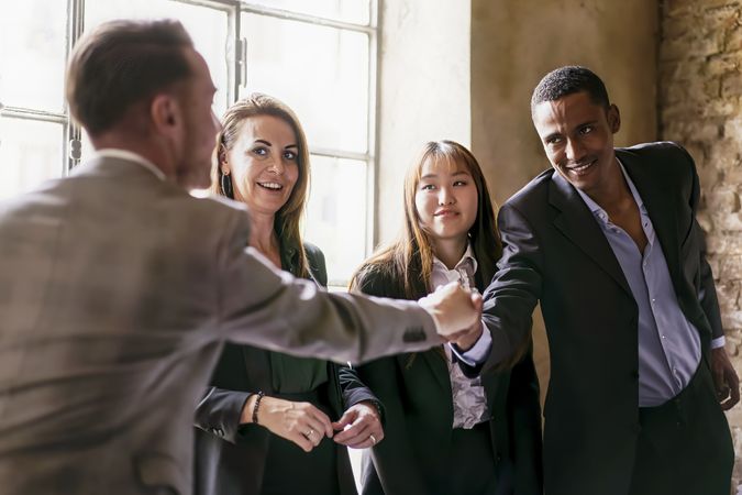 A group of young multi-ethnic entrepreneurs shaking hands during a working business