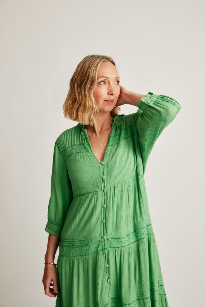 Blonde woman in green dress in studio