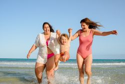 Happy family walking on beach