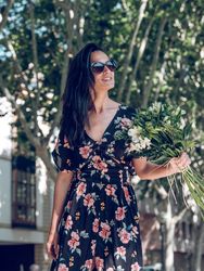 Cheerful female with bouquet of flowers in city