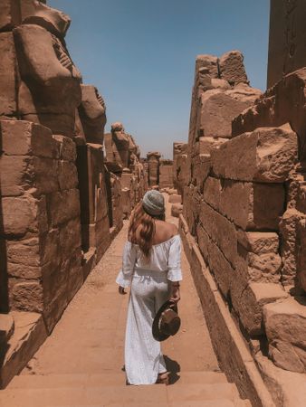 Woman walking between ancient ruins