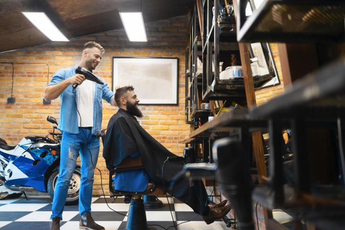 Barber blowdrying his client’s hair