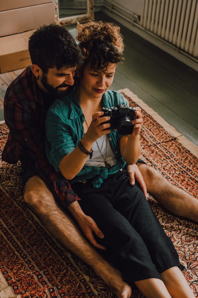 Young couple using photo camera at home