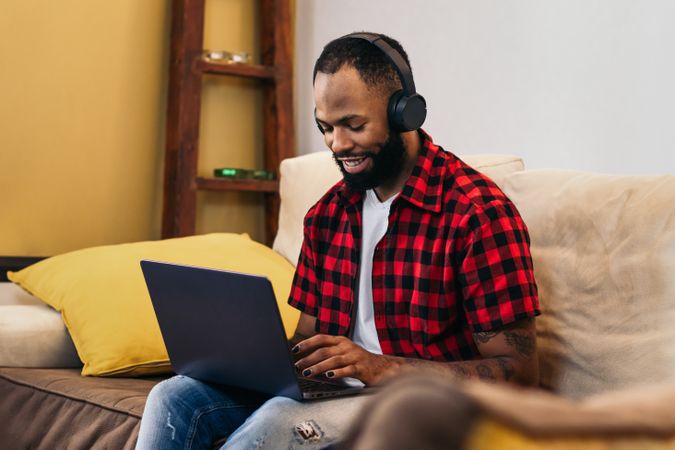 Black man teleworking with laptop from home